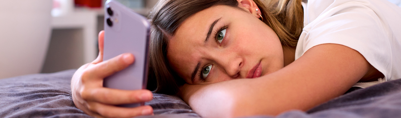 A teen victim of sextortion looking at phone
