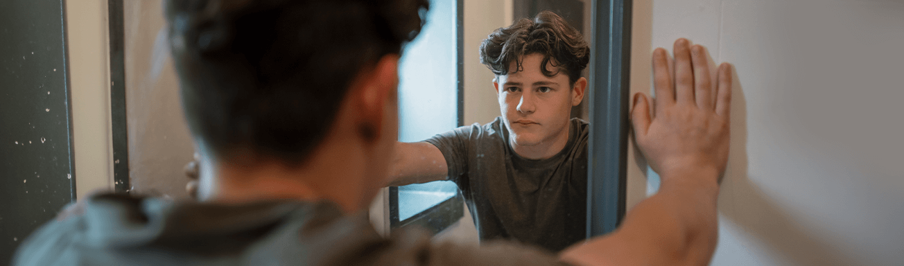 boy looking at himself in mirror